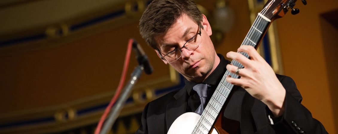 Image of Christopher Ladd playing his guitar