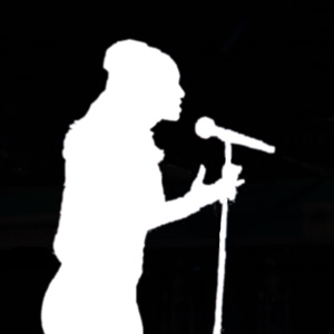 White silhouette of a woman speaking emphatically into a microphone on a stand.