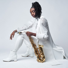 Lakecia Benjamin posing with her saxophone.