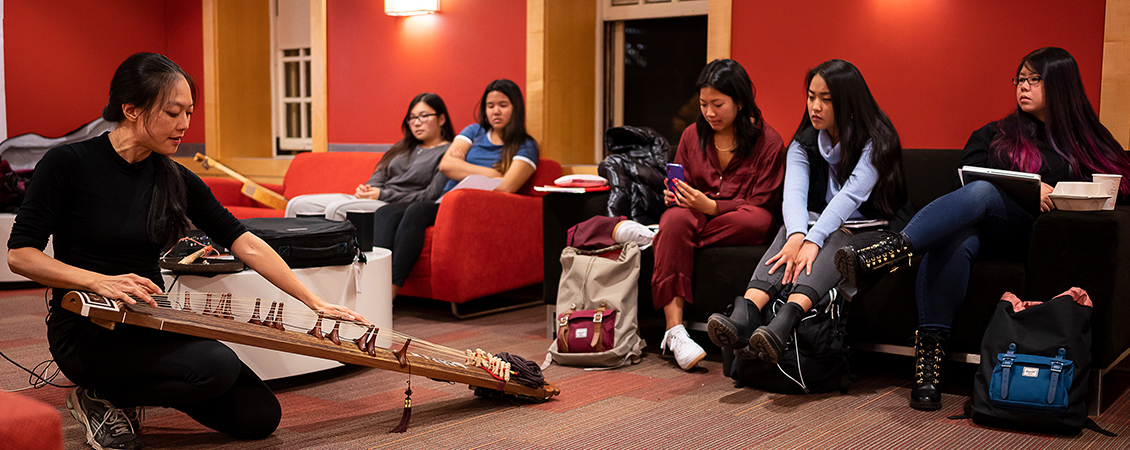 an image of students learning about the gu zheng from a gu zheng player
