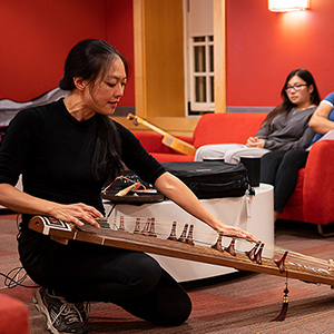 an image of students learning about the gu zheng from a gu zheng player
