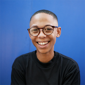 an image of Najja Moon smiling into the camera against a bright blue background