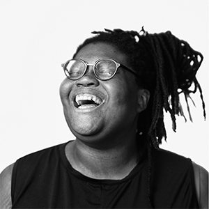 a black and white image of Michelle Lisa Polissaint laughing with eyes closed