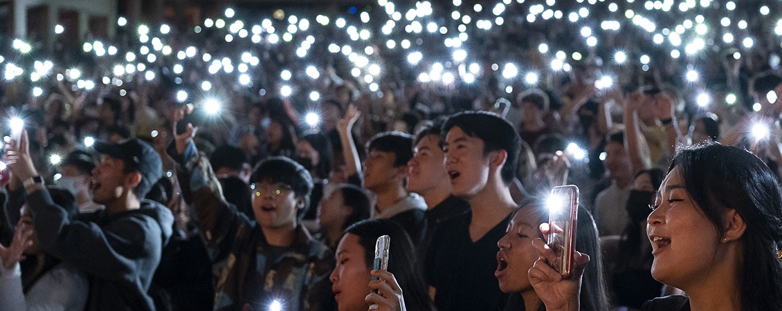 students raising torches at in Tillis Hall during the NIKI concert