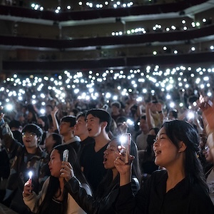 students raising torches at in Tillis Hall during the NIKI concert